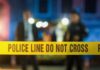 Mass Shooting Shocks Homecoming Crowd Police car with flashing blue lights at night.