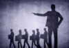 Layoffs Hit Streaming Giant Shadows of laid-off workers walking, large figure pointing.
