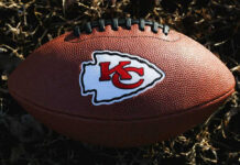 NFL Shock: Chief Dies Kansas City Chiefs football lying on the grass.