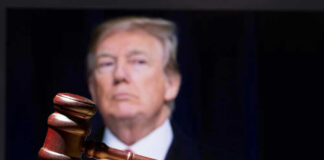 Donald Trump behind a judge’s gavel on a wooden surface