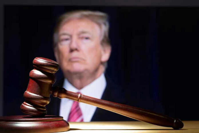 shutterstock_2284014577 Donald Trump behind a judge’s gavel on a wooden surface