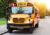 Yellow school bus with stop sign extended on a suburban street