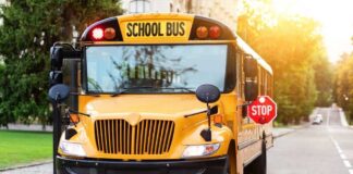 Yellow school bus with stop sign extended on a suburban street