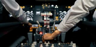 Pilots operate controls in an airplane cockpit