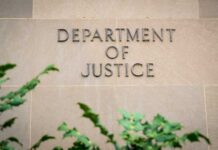 DOJ Raids Rattle State Elections Department of Justice building wall with engraved lettering