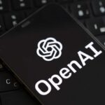 Smartphone displaying OpenAI logo on a keyboard
