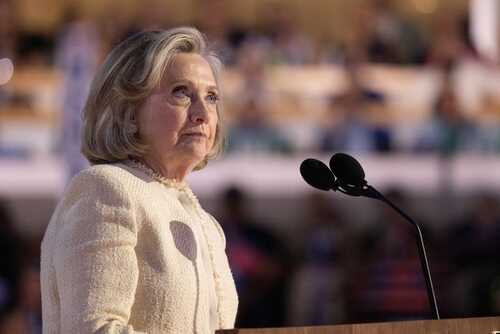 Hilary Cawthorne speaking at a podium with microphones