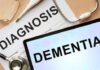 Medical diagnosis paperwork and a tablet displaying the word Dementia