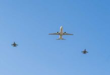 Mid-Flight Axe Attack Stuns Investigators A commercial airplane flying above two military jets in a clear blue sky