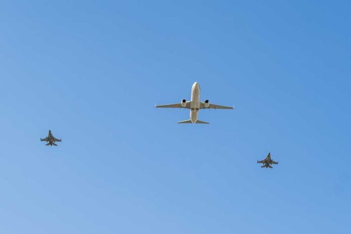 Boeing,737-800,Bbj2,Of,Polish,Government,Flying,Above,Military,Jets A commercial airplane flying above two military jets in a clear blue sky