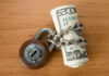 Rolled US dollars wrapped in chain with a padlock