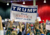 Large crowd holding Trump Make America Great Again sign.