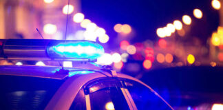 Police car with flashing blue lights at night.